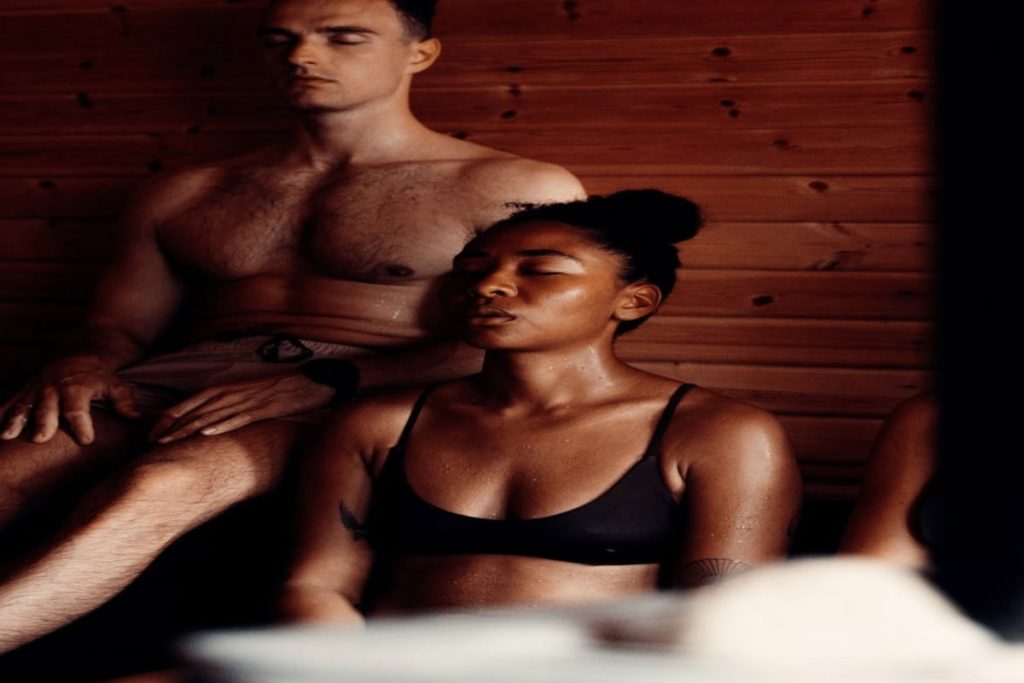Group experiencing an aufguss sauna session with steam and heat therapy for wellness and community bonding.